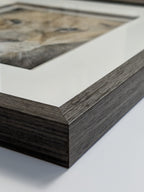 Close-up of a wooden picture frame with a blurred artwork inside.