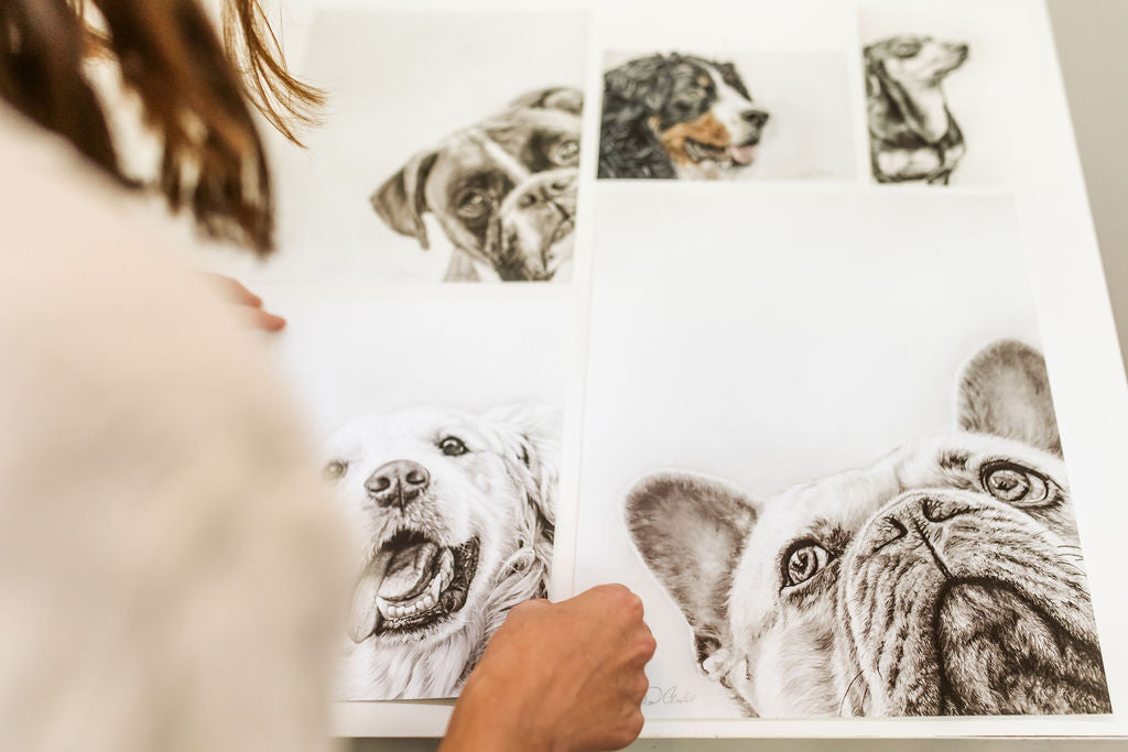 The artist showing detailed black and white sketchs of dog drawings