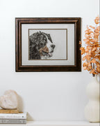 Framed artwork of a dog on a wall above a white cabinet with decorative items.