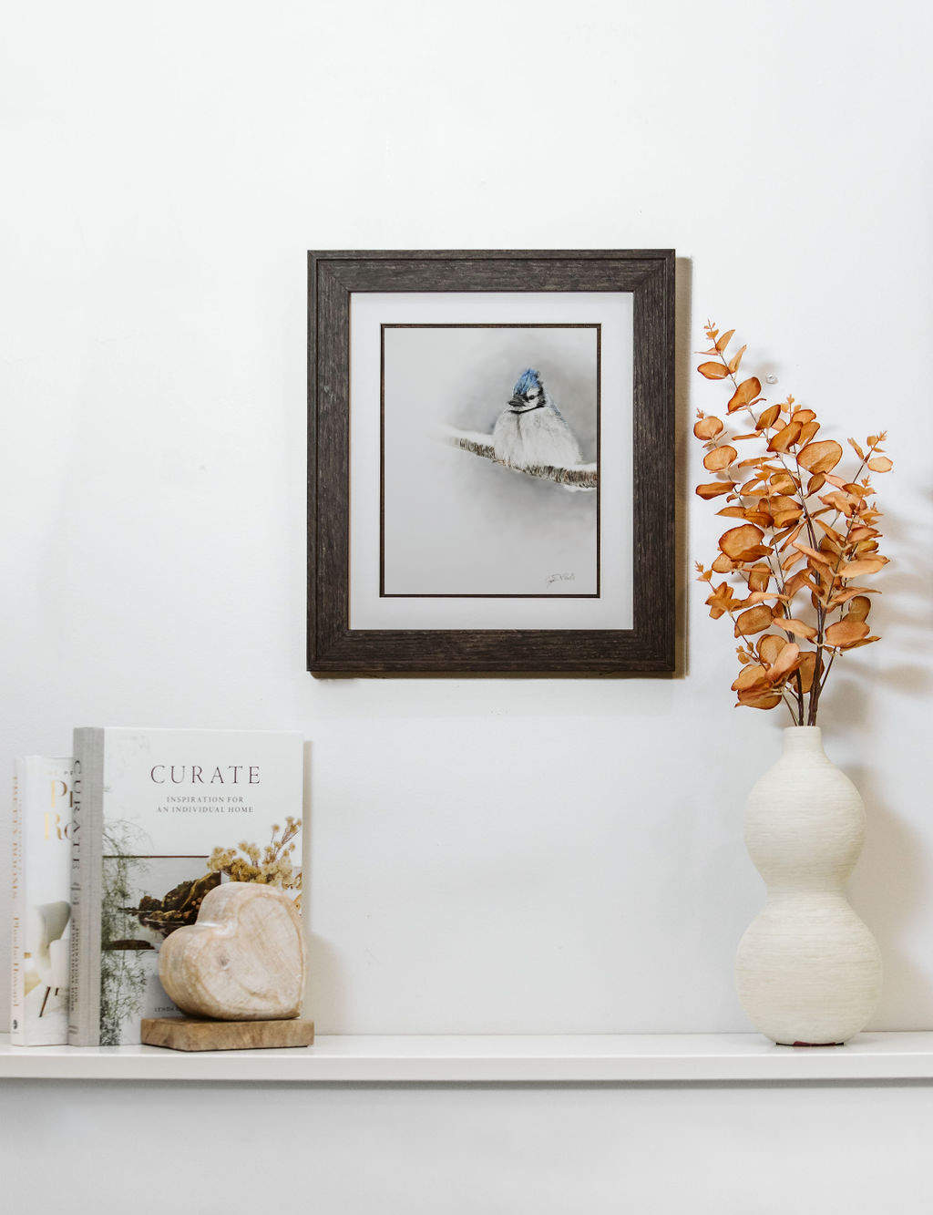 Framed pastel artwork of blue jay on a wall decorative items