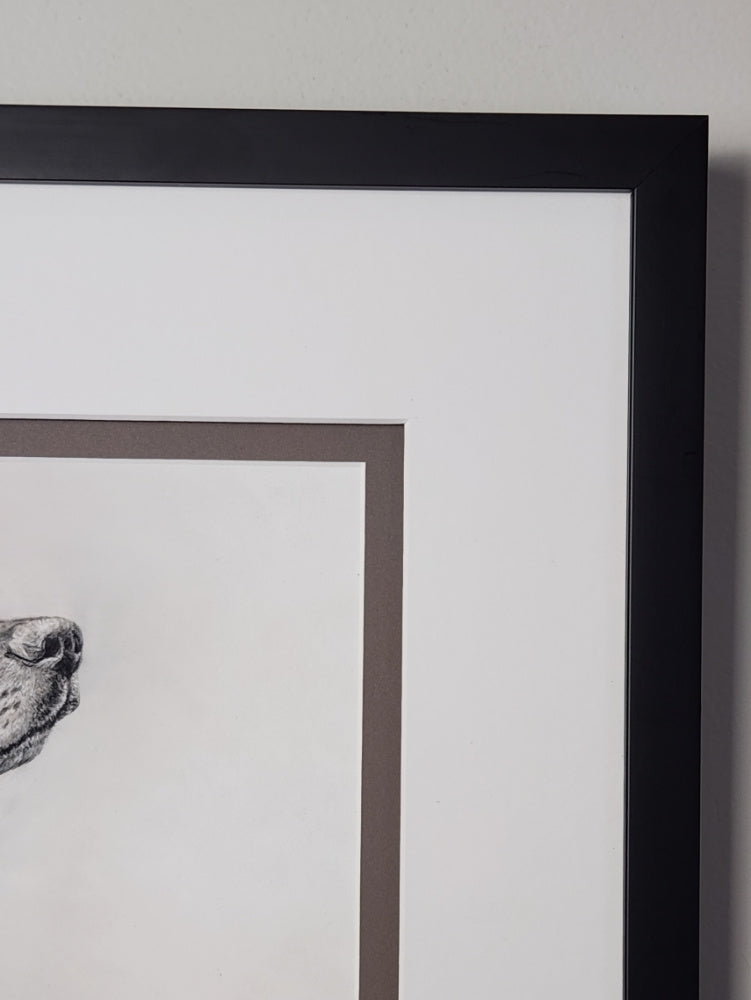Framed black and white artwork on a light gray wall