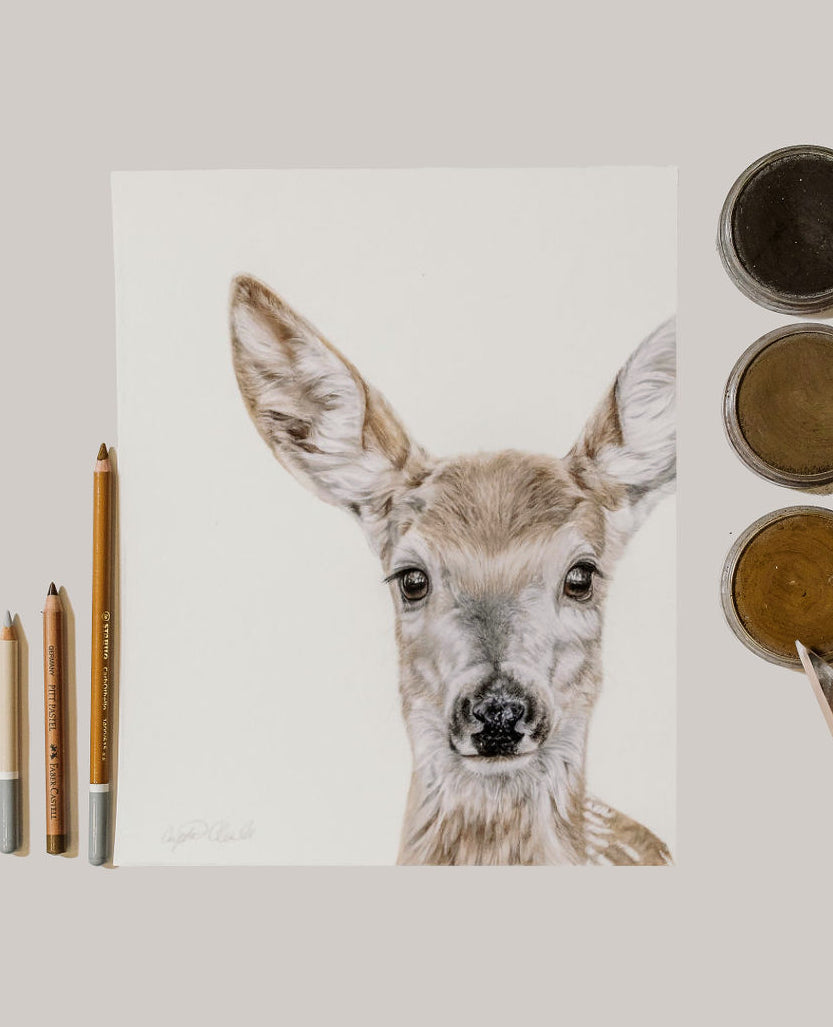 Deer painting with art supplies on a light gray background