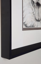 Close-up of a framed black and white artwork on a plain background