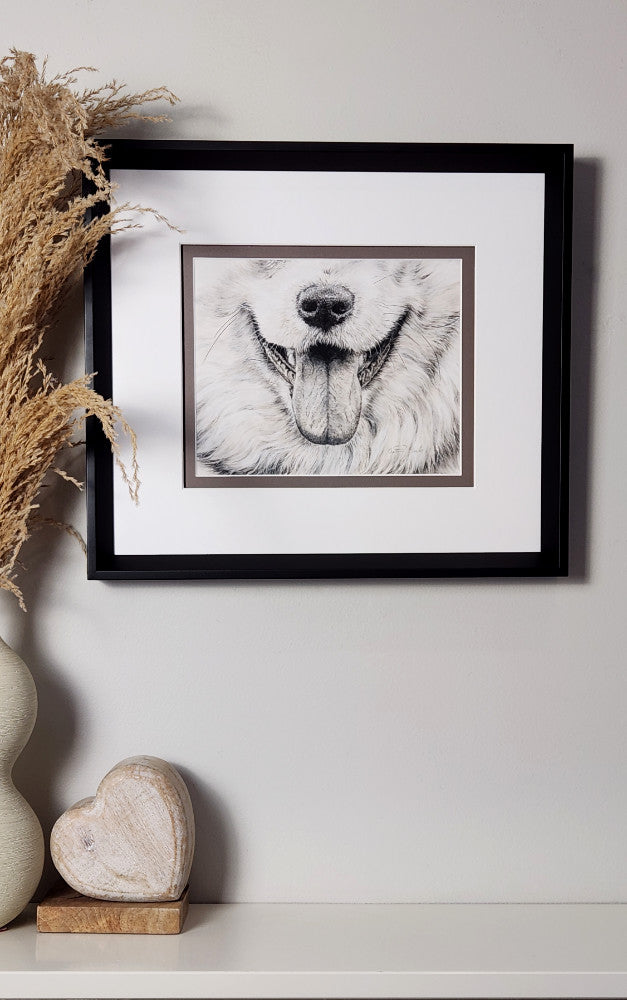 Framed black and white artwork of a dog's face on a wall with decorative elements.