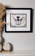 Framed black and white artwork of a dog's face on a wall with decorative elements.