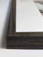 Close-up of a dark wooden picture frame on a white surface