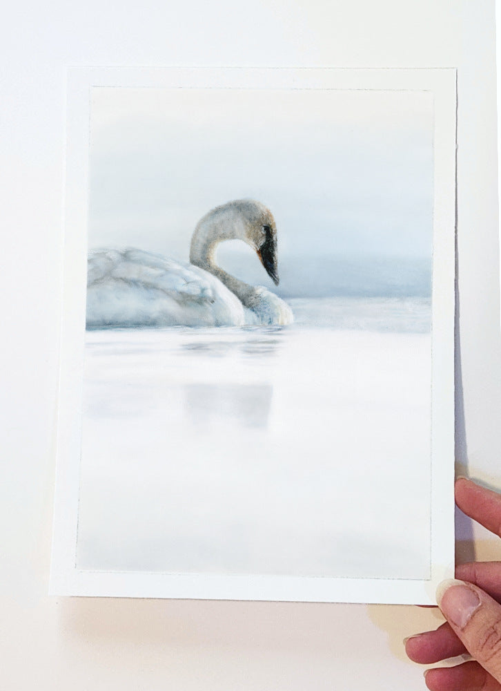 Artist Crystal Clarke holding an original drawing of a swan on water