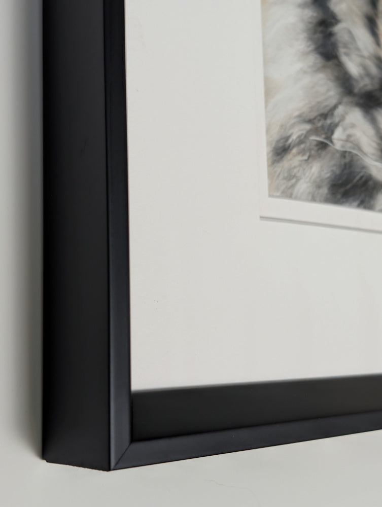Close-up of a black-framed picture on a light gray background