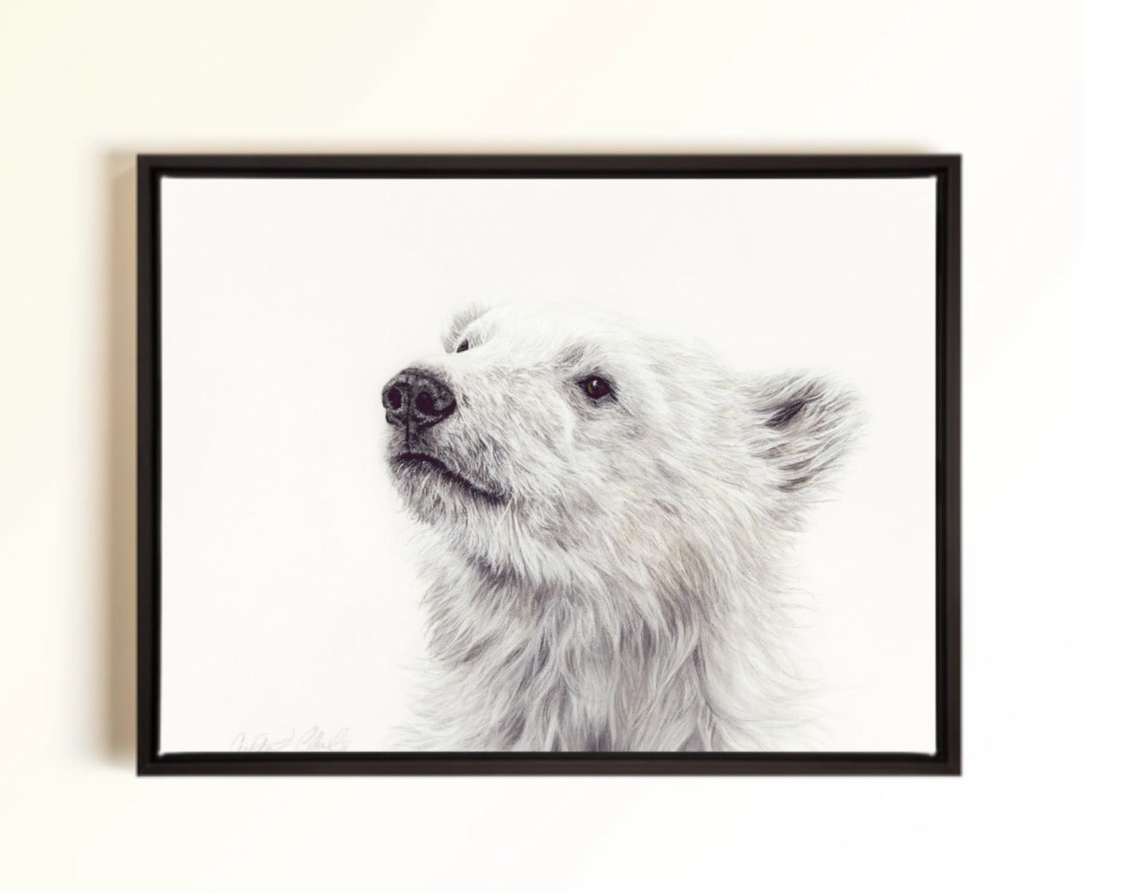 A framed canvas print of a polar bear's head and upper neck, shown hanging on a light beige wall.