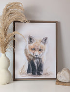 Framed artwork of a drawn fox on a wall with decorative elements.