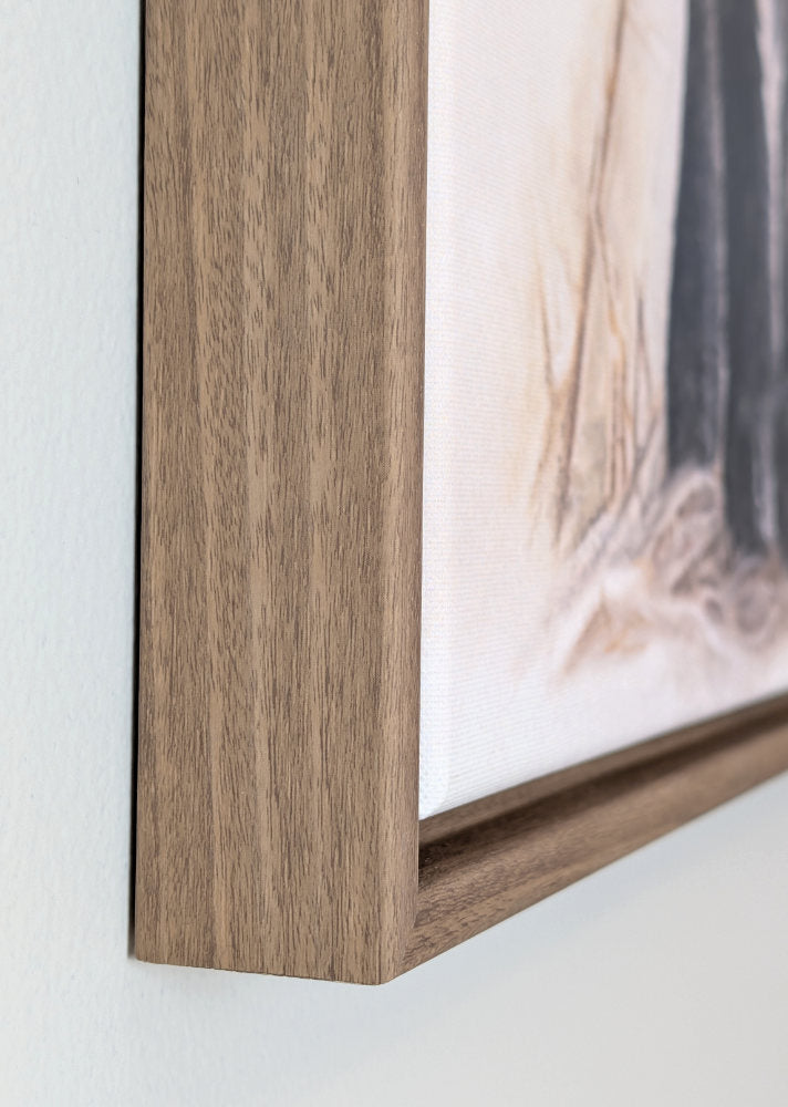 Close-up of a wooden picture frame with a blurred artwork background