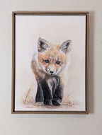 Framed artwork of a fox cub drawing 
on a white wall